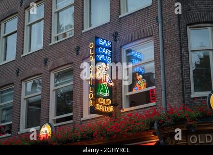 Amsterdam, Hollande - 17 août 2017 ; panneau Neon pour Old Sailor pub au-dessus de la véranda et des géraniums rouges sur le côté du bâtiment en brique