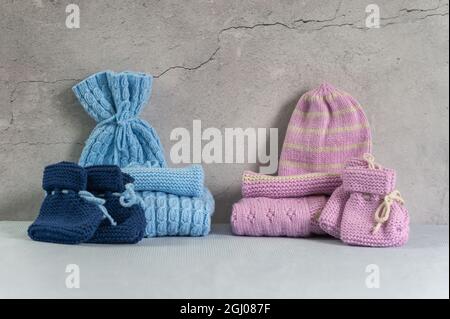 Vêtements de bébé chauds tricotés faits maison bleus et roses. Banque D'Images