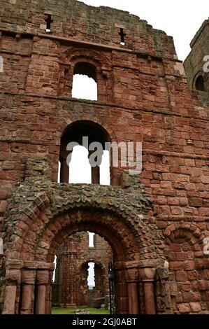 Vue extérieure sur les ruines d'un édifice prieuré médiéval de l'île de Lindisfarne dans le Northumberland. Banque D'Images