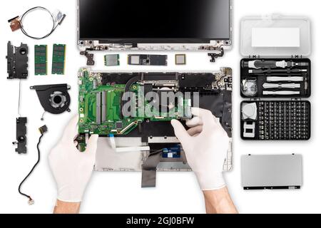 technicien avec des gants, fixer la réparation de la carte mère dans la vue de dessus. isolé sur fond blanc. pièces d'ordinateur et outils à main sur le bureau. Banque D'Images