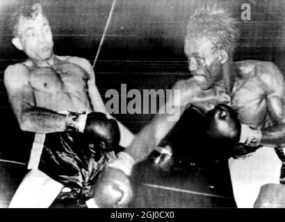 Joe Brown en train de saigner du coin de son œil gauche , oscille de manière extravagante et manque avec une droite alors que Carlos Ortiz recule pendant leur combat du titre World Lightweight à Las Vegas . 15 avril 1962 Banque D'Images