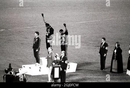 Les Jeux Olympiques de 1968, les médaillés d'or et de bronze de Mexico City America Tommie Smith (au centre) et John Carlos (à droite) élèvent leurs bras comme un geste de « puissance noire » lors de la cérémonie des Prix Olympiques. Smith avait établi un record du monde de 19.8 secondes dans la course de 200 mètres. Chaque homme portait un gant noir d'une main et le soulevait, le poing étant fermé au moment où le drapeau américain était levé. Peter Norman d'Australie (à gauche) a remporté la médaille d'argent. 16 octobre 1968. Banque D'Images