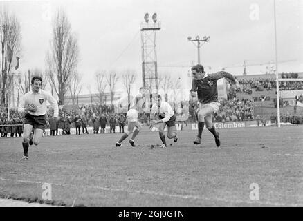 Le Français Pierre Villepreux (à gauche) court avec le ballon, le coéquipier Christian Carrere (au centre) se prépare au sauver du joueur irlandais (à droite) lors de l'Union internationale de rugby des cinq nations à Paris. 29 janvier 1968 Banque D'Images