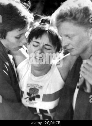 Kingston, Jamaïque: La Janet Simpson, en Angleterre, est assistée par les matres d'équipe Anne Smith (à gauche) et Pat Lowe (à droite) après qu'elle s'est effondrée à la fin de la finale féminine de 220 yards aux Jeux du Commonwealth à Kingston hier. Mlle Simpson s'était effondrée dans les bras de Mlle Smith et de Mlle Lowe, il y avait un incident impliquant un responsable des jeux. Lorsque les filles ont atteint Mlle Simpso qui s'était évanouie et a sauté sur le sol, elles ont été interceptées par le chef de la course A.Macintosh. Les filles ont plus tard prétendu qu'elles avaient été retirées de force de leur coéquipier alors qu'elles essayaient de la réconforter. 12 août 1966 Banque D'Images