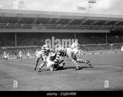 Londres: Coetzer de Wakefield (sur le terrain) tente de combattre Billy Boston (à droite) de Wigan comme il est attaqué pendant aujourd'hui, Rugby League Cup final entre les deux équipes au stade Wembley, Londres. Wakefield a remporté la coupe en battant Wigan le 25-10 11 mai 1963 Banque D'Images