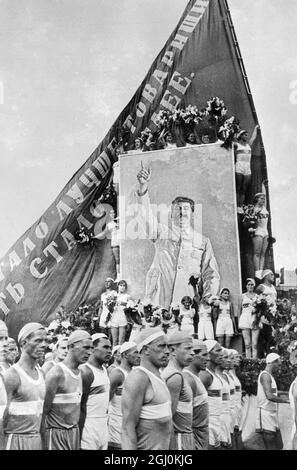 Les filles athlètes avec des fleurs ont encadré un portrait immense de Joseph Staline, dictateur soviétique qui a été défilé sur la place Rouge, Moscou, dans une grande parade de 75,000 athlètes et enfants en célébration de la Constitution soviétique. Les célébrations ont été les plus gayeuses jamais vues à Moscou depuis la Révolution, Selon le décret de Staline qui ''la vie est maintenant gayer et mieux''. 9 juillet 1936 Banque D'Images