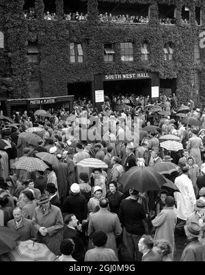 Les arrêts de pluie jouent à Wimbledon les spectateurs sont présentés avec des parasols en attente de pause par temps. 26 juin 1951 Banque D'Images