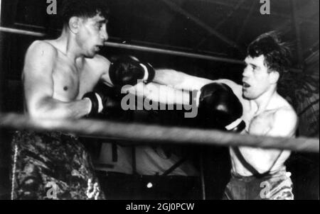 Vic Toweel , d'Afrique du Sud (à gauche) tire une longue gauche comme son adversaire , Luis Romero , le champion d'Espagne , contre avec un droit . Toweel a conservé son titre mondial de bantamweight dans ce concours de 15 tours avec une victoire décisive de points sur l'Espagnol , Johannesburg , Afrique du Sud . C'était la deuxième défense du titre du champion depuis qu'il l'a remporté de Manuel Ortiz , du Mexique , en mai 1950 . 20 novembre 1950 Banque D'Images