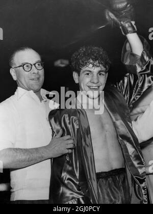 Le champion de poids-mouche de l'Empire britannique Dai Dower tient son gant en triomphe après sa victoire sur le Jake Tuli d'Afrique du Sud à Harringay Arena , Londres , Angleterre . 20 octobre 1954 Banque D'Images