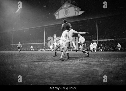 Le gardien de but Tottenham Hotspur Pat Jennings (jersey foncé) atteint un niveau élevé pour éviter une attaque de Millwall lors de la troisième répétition de la coupe de l'association de football à White Hart Lane le 1er février 1967 Banque D'Images