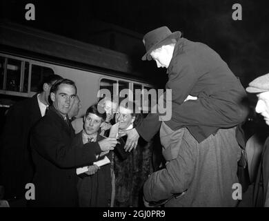 Ian Craig, 'bébé' de 17 ans de l'équipe australienne de tournée, signe des authographes pour vos fans de cricket à la gare de Waterloo quand l'équipe est arrivée en ville à bord du train de bateau Orcades 13 avril 1953 Banque D'Images