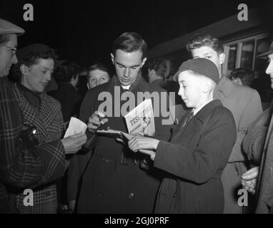 Ian Craig, 'bébé' de 17 ans de l'équipe australienne de tournée, signe des authographes pour vos fans de cricket à la gare de Waterloo quand l'équipe est arrivée en ville à bord du train de bateau Orcades 13 avril 1953 Banque D'Images