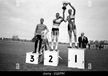 Briton bat champion du monde. Londres ; Hugh porter ( à droite ) , détient le trophée aloft après qu'il ait battu le champion du monde Tiemen Groen ( à gauche ) de Hollande dans la finale de poursuite de 4,000 mètres dans la réunion cycliste internationale à Herne Hill , Londres aujourd'hui. Porter a produit un excellent trajet pour battre le Dutchman d'un peu plus de six secondes. Près de 10,000 spectateurs ont vu la victoire britannique. 8 avril 1966 Banque D'Images