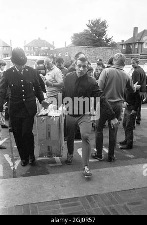 Welwyn Garden City, Herts : Horst Hottges en Allemagne de l'Ouest est photographié avec l'aide d'un policier britannique pour transporter un colis à l'hôtel Homstead court aujourd'hui. L'Allemagne de l'Ouest rencontrera l'Angleterre dans le dernier tournoi de la coupe du monde cet après-midi au stade Wembley. 30 juillet 1966 Banque D'Images