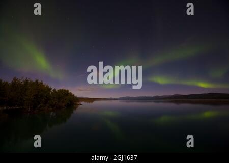 Canada, Yukon. Les lumières du nord se reflètent dans le lac Marsh à Tagish. Banque D'Images