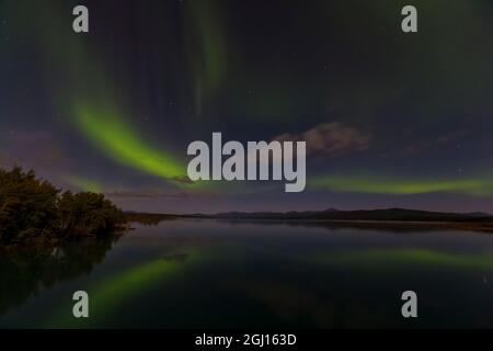 Canada, Yukon. Les lumières du nord se reflètent dans le lac Marsh à Tagish. Banque D'Images