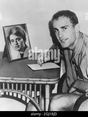 2 JANVIER 1964 L'ÉTOILE AUSTRALIENNE DE TENNIS JOHN NEWCOMBE ÉCRIT À SON COLLÈGUE DE TENNIS ANGELIKA PFANENBURG D'ALLEMAGNE PENDANT UNE LONGUE DISTANCE ROMANTIQUE QUI A COMMENCÉ À WIMBLEDON L'ANNÉE DERNIÈRE. LONGUEVILLE, AUSTRALIE. Banque D'Images