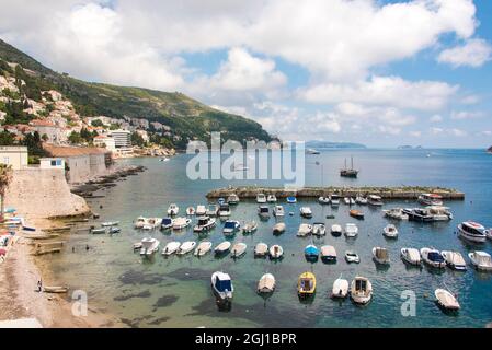 Croatie, Dubrovnik. Vue sur la marina et la côte depuis le mur de la vieille ville. Le pêcheur se tient sur la rive. Banque D'Images