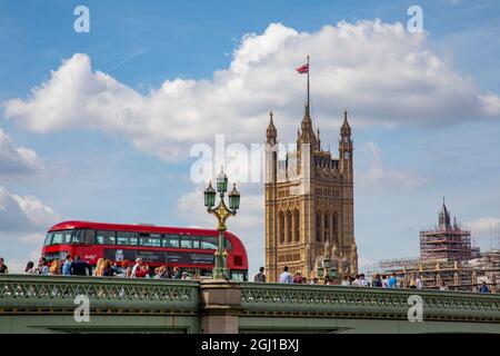 Bus classique à impériale à Londres, en Angleterre, traversant le pont sur la Tamise avec le Parlement en arrière-plan. Banque D'Images