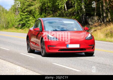 Voiture électrique Red Tesla modèle 3 sur route. Le modèle 3 dispose d'une capacité d'auto-conduite complète qui peut être activée en option. Salo, Finlande. 13 août 2021. Banque D'Images