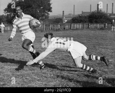 Emmanuel McDonald Bailey sur le point de devenir un professionnel de la Ligue de rugby avec Leigh Lancashire Rugby League football Club, qui s'attaque à Harold Clough 1953 Banque D'Images