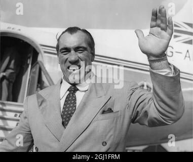 Primo se rend à la maison Une vague de l'une de ces mains énormes comme l'ancien champion du monde de boxe Primo Carnera va à bord d'un avion BEA à l'aéroport de Londres . Il vole à Rome après avoir filmé des scènes de lutte pour '' Un enfant pour deux Farthings '' aux Shepperton Studios , Middlesex . 4 octobre 1954 Banque D'Images