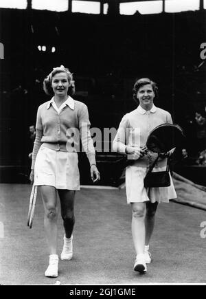 Mme A.J. Mottram (À GAUCHE, Grande-Bretagne) et Mme W. du Pont (à droite, États-Unis) marchent jusqu'à Center court à Wimbledon pour leur premier match des dames célibataires. Mme du Pont a gagné 6-3, 6-4. La pièce a été maintenue pendant plusieurs heures par la pluie. 26 juin 1951 Banque D'Images