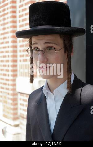 Pose du portrait d'un adolescent juif hassidique sur Lee avenue à Williamsburg, Brooklyn, New York Banque D'Images