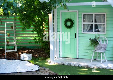 Façade Maison décorée pour les vacances d'automne.Extérieur porche maison en bois avec meubles de jardin. Véranda maison avec chaise et panier de fleurs. Banque D'Images