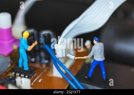 Personnes miniatures : équipe de travail réparant les circuits électroniques. , concept des travailleurs de la construction Banque D'Images