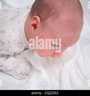 Un Bebe Age De 1 Mois Apprend A Garder Sa Tete Allongee Sur Son Ventre Un Enfant De Race Blanche Dans Une Chambre Blanche A La Maison Photo Stock Alamy