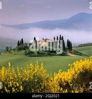 Ferme toscane avec cyprès dans un paysage brumeux au lever du soleil, San Quirico d'Orcia, province de Sienne, Toscane, Italie, Europe Banque D'Images