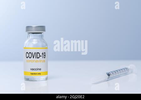 Vaccin en flacon en verre avec seringue sur une table. Vaccination et concept médical. Banque D'Images