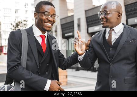 Rencontre de deux amis de longue date de l'homme d'affaires afro-américain noir en costumes à l'extérieur Banque D'Images