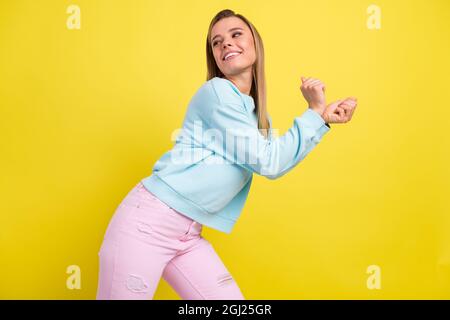 Portrait d'une jolie fille gaie dansant ayant le plaisir de temps libre clubbing isolé sur fond jaune vif de couleur Banque D'Images