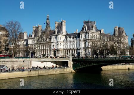 Des foules de gens qui profitent du soleil en hiver sur les quais de Seine près de l'Hôtel de ville à Paris, France Banque D'Images