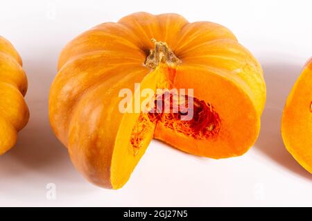 Grand potiron orange frais entier et une tranche de potiron sur fond blanc, gros plan. Produit agricole biologique, ingrédients pour cuisiner, aliments sains Banque D'Images