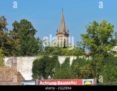 08 septembre 2021, Brandebourg, Oranienburg : le reste d'un mur de l'ancienne brasserie Kindl se trouve sur le site commémoratif de l'ancien camp de concentration d'Oranienburg dans la Berliner Straße, en face de la toile de fond de l'église de la ville de Saint-Nikolai. En mars 1933, la sa locale avait établi le premier camp de concentration de Prusse dans l'ancienne brasserie. Jusqu'à la fermeture du camp en juillet 1934, environ 3000 prisonniers d'Oranienburg et des environs ainsi que de Berlin ont été internés ici. Au moins 16 des prisonniers sont morts dans le camp de concentration d'Oranienburg, dont l'écrivain Mühsam. TH Banque D'Images