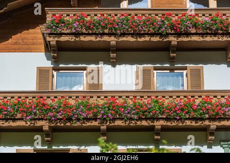 Le balcon en bois d'une ancienne ferme de montagne avec des fleurs colorées en Autriche, gros plan Banque D'Images