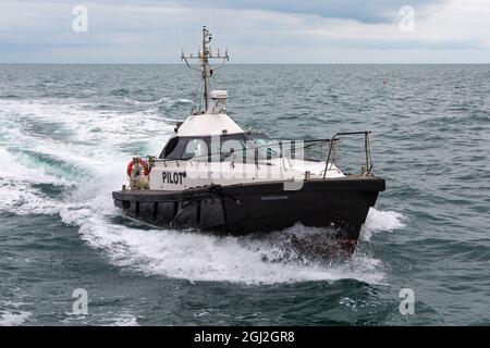 Le bateau-pilote Barracuda accueille un navire entrant dans le port de Poole, Poole, Dorset, Royaume-Uni en août Banque D'Images