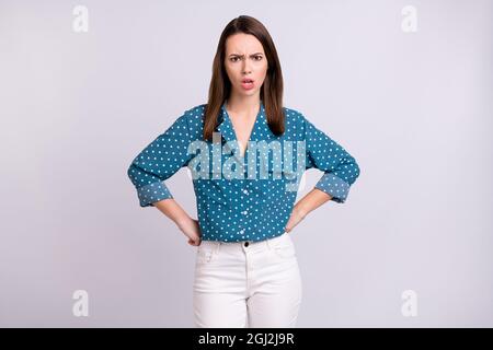 Photo de la colère brunette cheveux jeune femme mains taille porter chemise bleu jeans blanc isolé sur fond gris couleur Banque D'Images