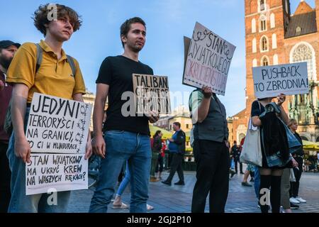 Cracovie, Pologne. 3 septembre 2021. Les manifestants tiennent des pancartes exprimant leur opinion pendant la manifestation.les manifestants ont manifesté contre l'introduction de l'état d'urgence sur la frontière biélorusse polonaise, sur la place principale inscrite au patrimoine mondial de l'UNESCO à Cracovie. Le gouvernement de la Pologne a instauré un état d'urgence dans deux régions limitrophes de la Biélorussie alors qu'un afflux de migrants du Moyen-Orient se produit. Pendant ce temps, plus de 30 000 personnes en provenance d'Afghanistan ont été coincées pendant plus de trois semaines entre les gardes biélorusses armés d'un côté et les forces polonaises armées de l'autre. Certains sont malades comme le Banque D'Images