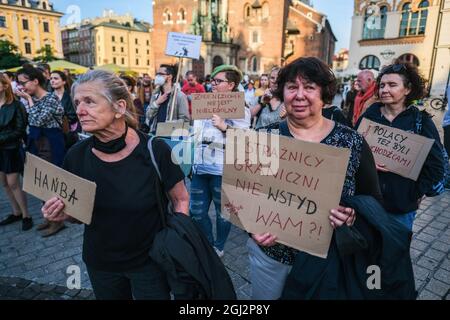 Cracovie, Pologne. 3 septembre 2021. Les manifestants tiennent des pancartes exprimant leur opinion pendant la manifestation.les manifestants ont manifesté contre l'introduction de l'état d'urgence sur la frontière biélorusse polonaise, sur la place principale inscrite au patrimoine mondial de l'UNESCO à Cracovie. Le gouvernement de la Pologne a instauré un état d'urgence dans deux régions limitrophes de la Biélorussie alors qu'un afflux de migrants du Moyen-Orient se produit. Pendant ce temps, plus de 30 000 personnes en provenance d'Afghanistan ont été coincées pendant plus de trois semaines entre les gardes biélorusses armés d'un côté et les forces polonaises armées de l'autre. Certains sont malades comme le Banque D'Images