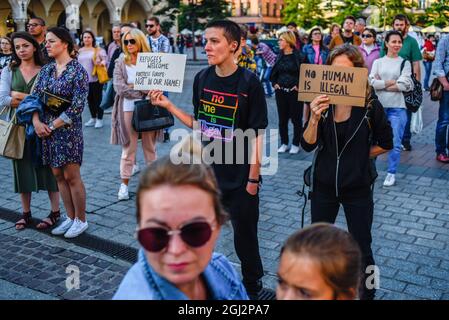 Cracovie, Pologne. 3 septembre 2021. Les manifestants tiennent des pancartes exprimant leur opinion pendant la manifestation.les manifestants ont manifesté contre l'introduction de l'état d'urgence sur la frontière biélorusse polonaise, sur la place principale inscrite au patrimoine mondial de l'UNESCO à Cracovie. Le gouvernement de la Pologne a instauré un état d'urgence dans deux régions limitrophes de la Biélorussie alors qu'un afflux de migrants du Moyen-Orient se produit. Pendant ce temps, plus de 30 000 personnes en provenance d'Afghanistan ont été coincées pendant plus de trois semaines entre les gardes biélorusses armés d'un côté et les forces polonaises armées de l'autre. Certains sont malades comme le Banque D'Images