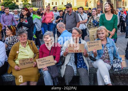 Cracovie, Pologne. 3 septembre 2021. Les manifestants tiennent des pancartes exprimant leur opinion pendant la manifestation.les manifestants ont manifesté contre l'introduction de l'état d'urgence sur la frontière biélorusse polonaise, sur la place principale inscrite au patrimoine mondial de l'UNESCO à Cracovie. Le gouvernement de la Pologne a instauré un état d'urgence dans deux régions limitrophes de la Biélorussie alors qu'un afflux de migrants du Moyen-Orient se produit. Pendant ce temps, plus de 30 000 personnes en provenance d'Afghanistan ont été coincées pendant plus de trois semaines entre les gardes biélorusses armés d'un côté et les forces polonaises armées de l'autre. Certains sont malades comme le Banque D'Images