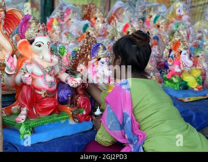 Beawar, Rajasthan, Inde, 8 septembre 2021 : un artiste donne une touche finale à une idole du seigneur de dieu hindou à tête d'éléphant Ganpati dans un magasin de bord de route en prévision du festival Ganesh Chaturthi à Beawar. Ganesh Chaturthi sera célébré en Inde à partir de septembre 10. Les dévotés installent des idoles d'argile à la maison pour adorer Lord Ganesha pendant cette période. Les célébrations de Ganesh Chaturthi dans les lieux publics ne seront pas autorisées en raison de la pandémie COVID-19. Crédit : Sumit Saraswat/Alay Live News Banque D'Images