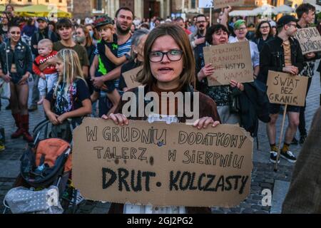 Cracovie, Pologne. 3 septembre 2021. Les manifestants tiennent des pancartes exprimant leur opinion pendant la manifestation.les manifestants ont manifesté contre l'introduction de l'état d'urgence sur la frontière biélorusse polonaise, sur la place principale inscrite au patrimoine mondial de l'UNESCO à Cracovie. Le gouvernement de la Pologne a instauré un état d'urgence dans deux régions limitrophes de la Biélorussie alors qu'un afflux de migrants du Moyen-Orient se produit. Pendant ce temps, plus de 30 000 personnes en provenance d'Afghanistan ont été coincées pendant plus de trois semaines entre les gardes biélorusses armés d'un côté et les forces polonaises armées de l'autre. Certains sont malades comme le Banque D'Images