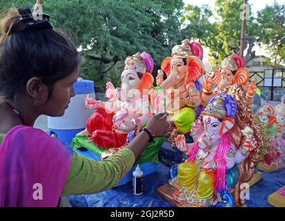 Beawar, Rajasthan, Inde, 8 septembre 2021 : un artiste donne une touche finale à une idole du seigneur de dieu hindou à tête d'éléphant Ganpati dans un magasin de bord de route en prévision du festival Ganesh Chaturthi à Beawar. Ganesh Chaturthi sera célébré en Inde à partir de septembre 10. Les dévotés installent des idoles d'argile à la maison pour adorer Lord Ganesha pendant cette période. Les célébrations de Ganesh Chaturthi dans les lieux publics ne seront pas autorisées en raison de la pandémie COVID-19. Crédit : Sumit Saraswat/Alay Live News Banque D'Images