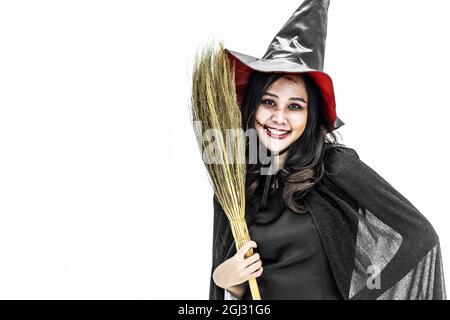 Halloween Party Girl, Beauty femme asiatique avec de longs cheveux debout et souriant tenant bâton de couve Banque D'Images