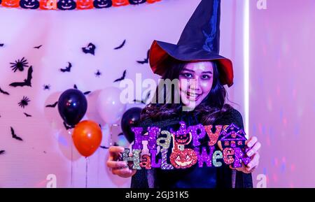 Fête d'Halloween avec une fille tenant une bonne affiche d'Halloween en main Banque D'Images